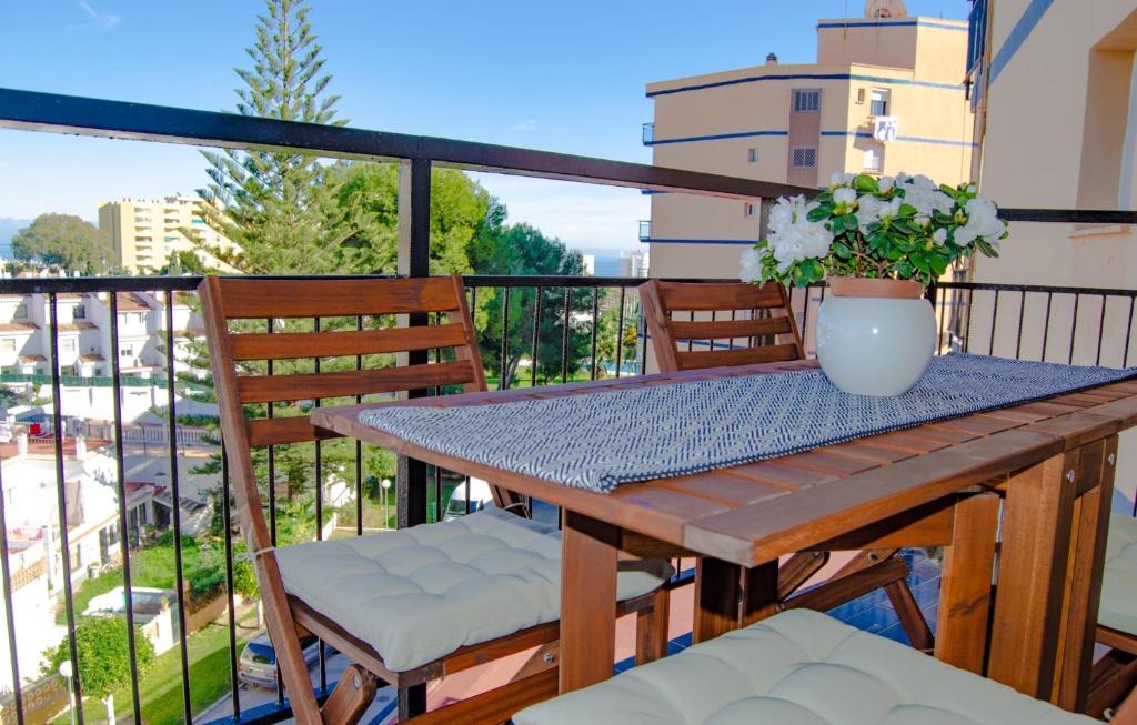 stół i krzesła na balkonie z wazonem kwiatów w obiekcie Mar del Sur Bonito w mieście Benalmádena