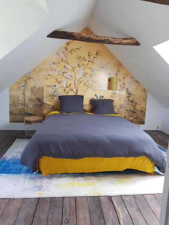1 dormitorio con 1 cama grande y pared de flores en Hameau de Leignoua, en Le Saint