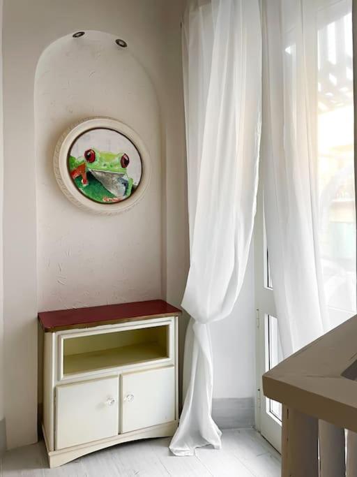 a white room with a frog picture on the wall at Bau!House in Piombino