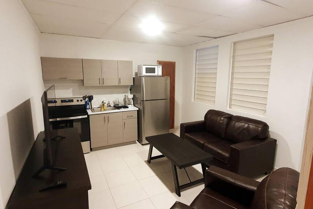 a kitchen with a couch and a chair in a room at Cozy Apt near Pinero Train Stop in San Juan