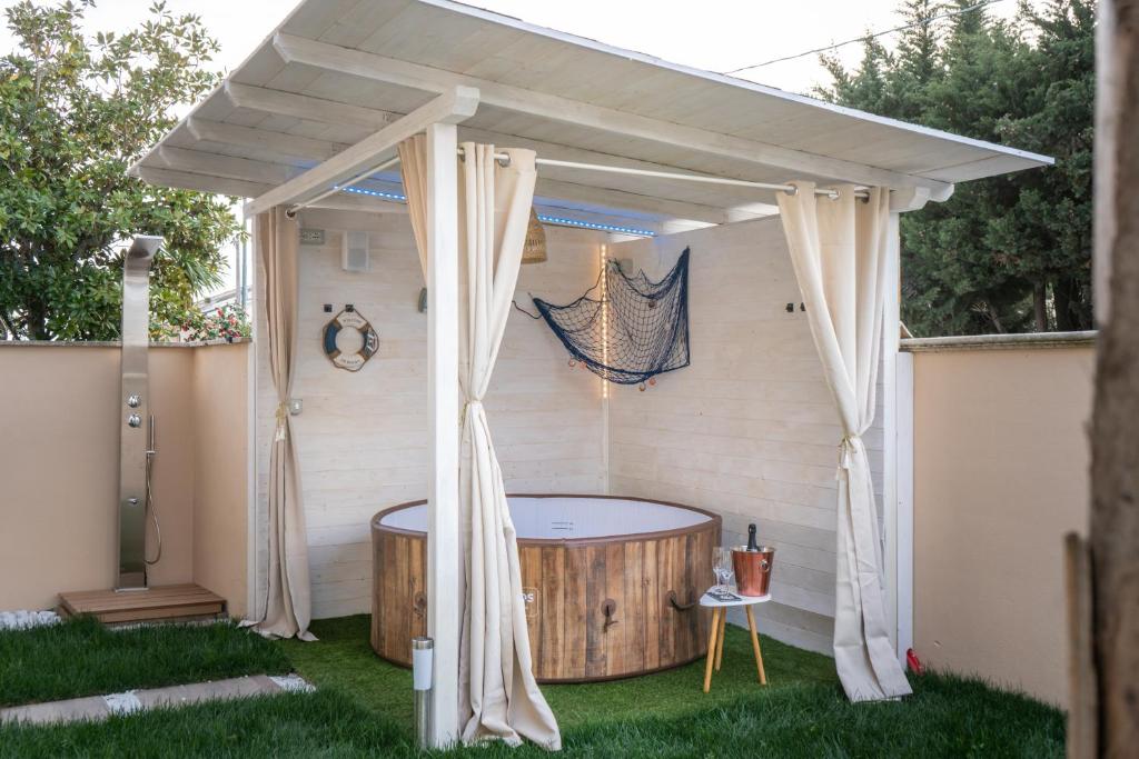 um gazebo com uma banheira de hidromassagem num quintal em Relaxroombeach em Anzio