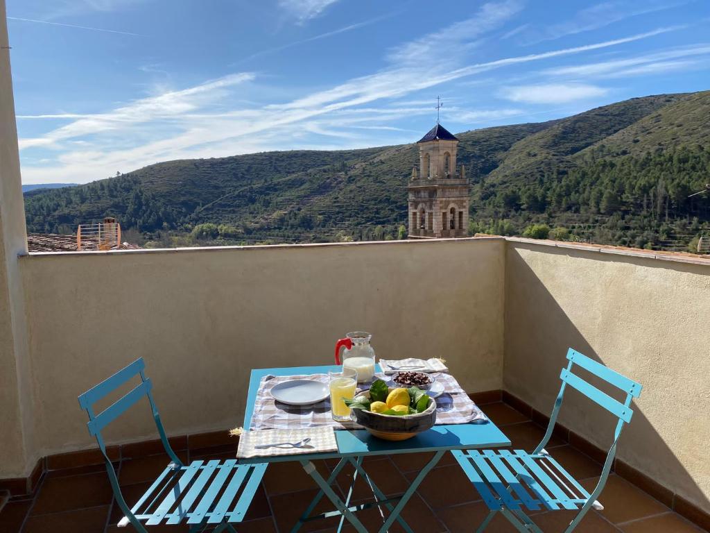 a table with a bowl of fruit and two chairs on a balcony at Casa Rural Lavadero en Teresa 