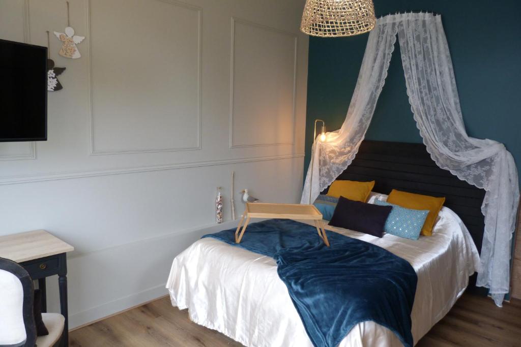 une chambre avec un lit à baldaquin dans l'établissement Le cocon des Ancelyns, au Teich