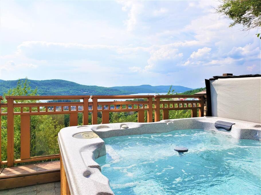 a hot tub on a deck with a view of the mountains at ALTITUDE 170-2 / PRIVATE Hot Tub on HUGE Terrace in Mont-Tremblant