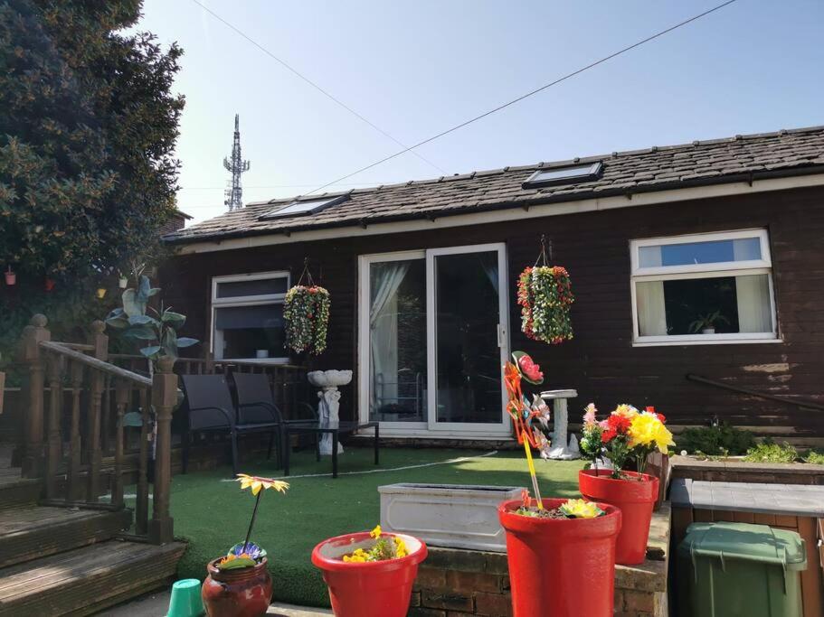 uma casa com vasos de flores em frente em Wimpole Lounge em Oldham