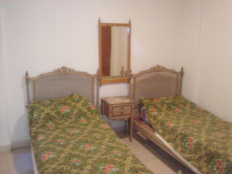 2 camas en una habitación con espejo y espejo en Miramar departamento 2 ambientes frente al mar en Miramar