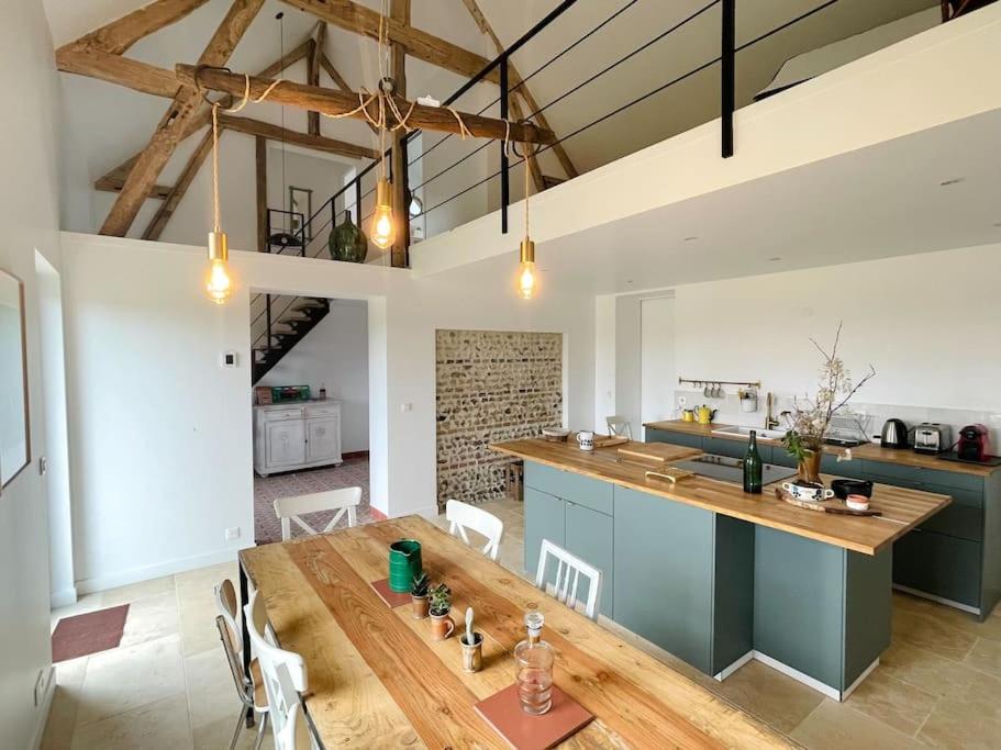 Il comprend une cuisine et une salle à manger avec une table en bois. dans l'établissement La Grange du Bois Germain, à Saint-Antonin-de-Sommaire