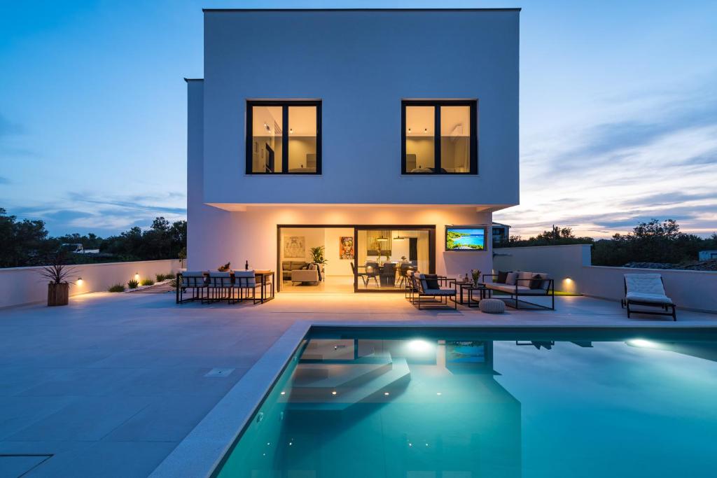 a villa with a swimming pool at night at Villa Kurnatari in Jezera