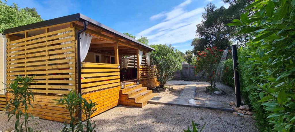 a small wooden cabin with a staircase leading to it at Mobile Home Shelbox in Biograd na Moru