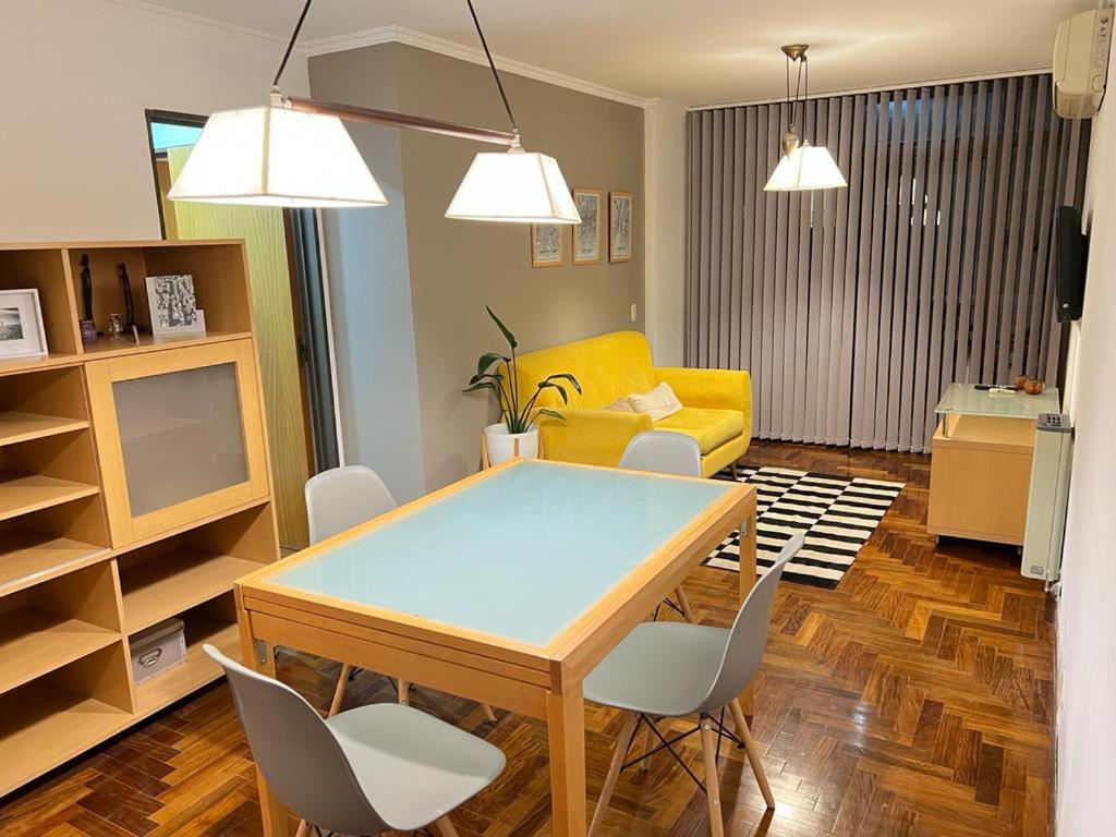 sala de estar con mesa de comedor y sofá amarillo en Larrañaga 2 dorm. Nueva Córdoba en Córdoba