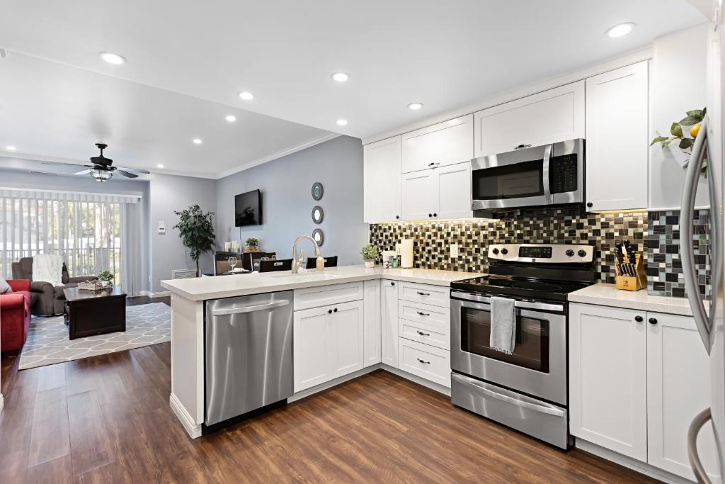 a kitchen with white cabinets and a stove top oven at 629 Walk to Restaurants Close to Golf and Spa Luxury Inside the gates in Encinitas