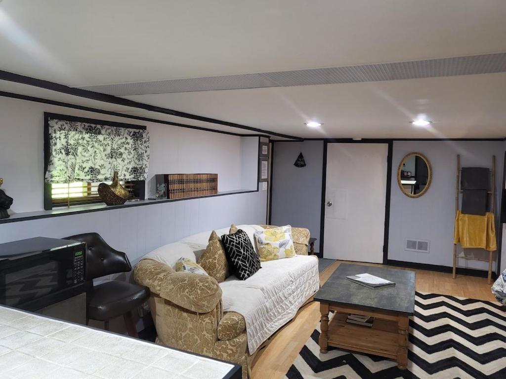 uma sala de estar com um sofá e uma mesa em Legend Rock Lodge em South Kingstown