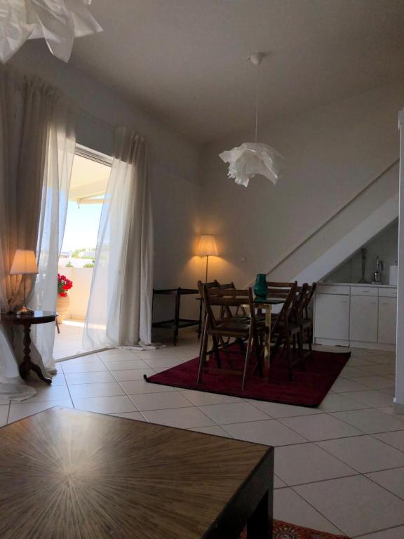 salon ze stołem i krzesłami w obiekcie Pounta Beach House w mieście Sunion