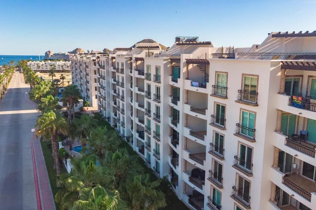 uma vista aérea de um edifício com palmeiras e uma rua em Condo Maravilla - New luxurious condo 300mt from the beach em Cabo San Lucas
