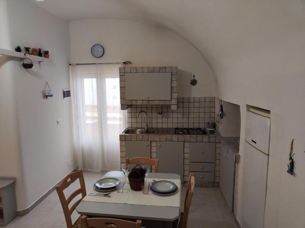 une cuisine avec une table, des chaises, une table et une table. dans l'établissement Dimora La Chianca, à Marina Serra