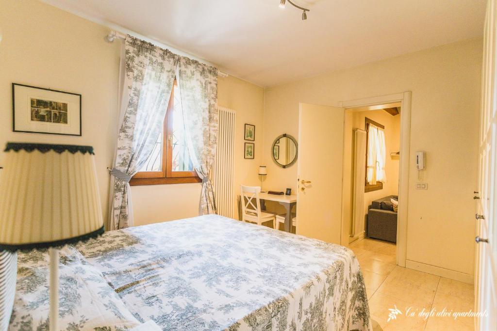 a bedroom with a bed and a window and a desk at Ca' degli Ulivi - Oliva Verde in Creazzo