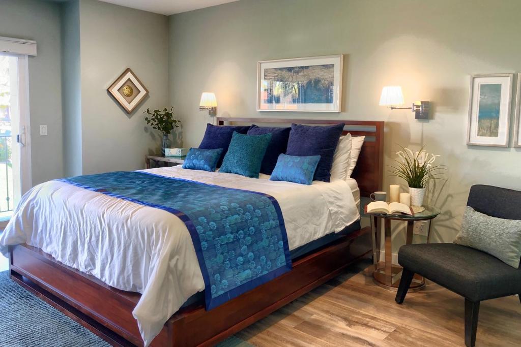 - une chambre avec un lit doté d'oreillers bleus et d'une chaise dans l'établissement 631 Remodeled La Costa Retreat steps from the Resort Spa, PFC and Golf, à Encinitas