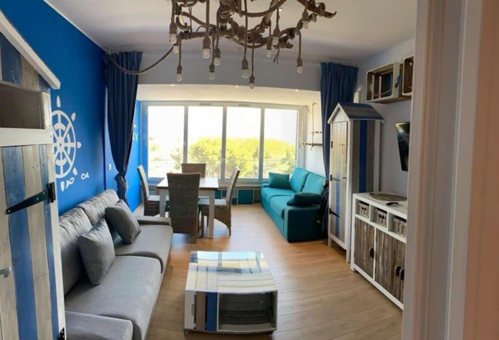 a living room with a couch and a table at Athéna OHANA, les pieds dans l'eau in Bandol