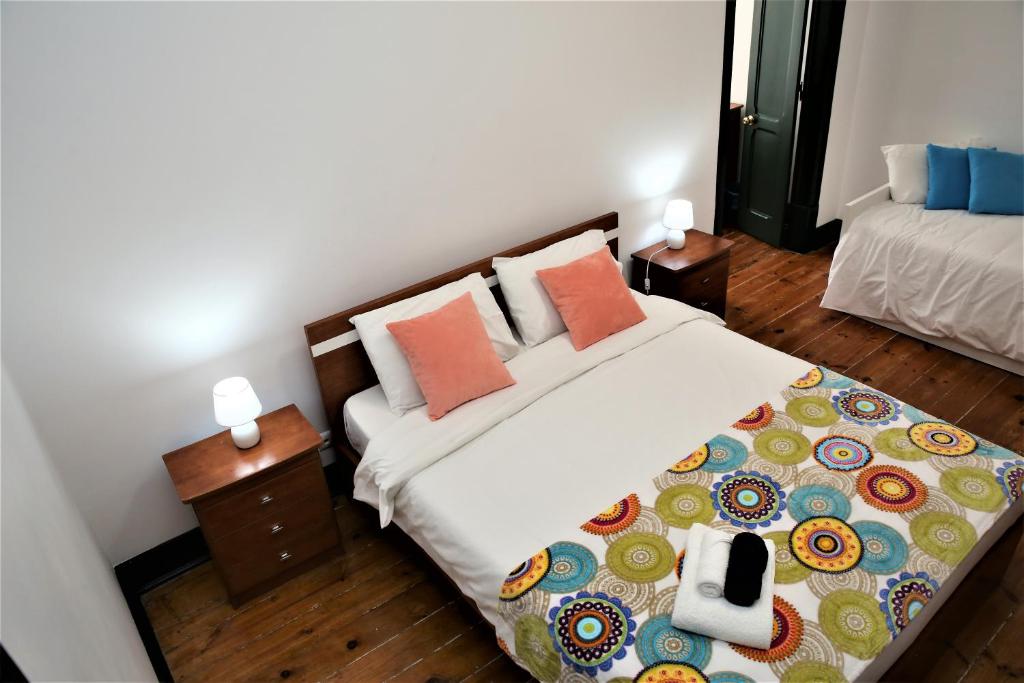 ein Schlafzimmer mit einem Bett mit zwei Nachttischen und zwei Lampen in der Unterkunft Family Bedroom in Lissabon