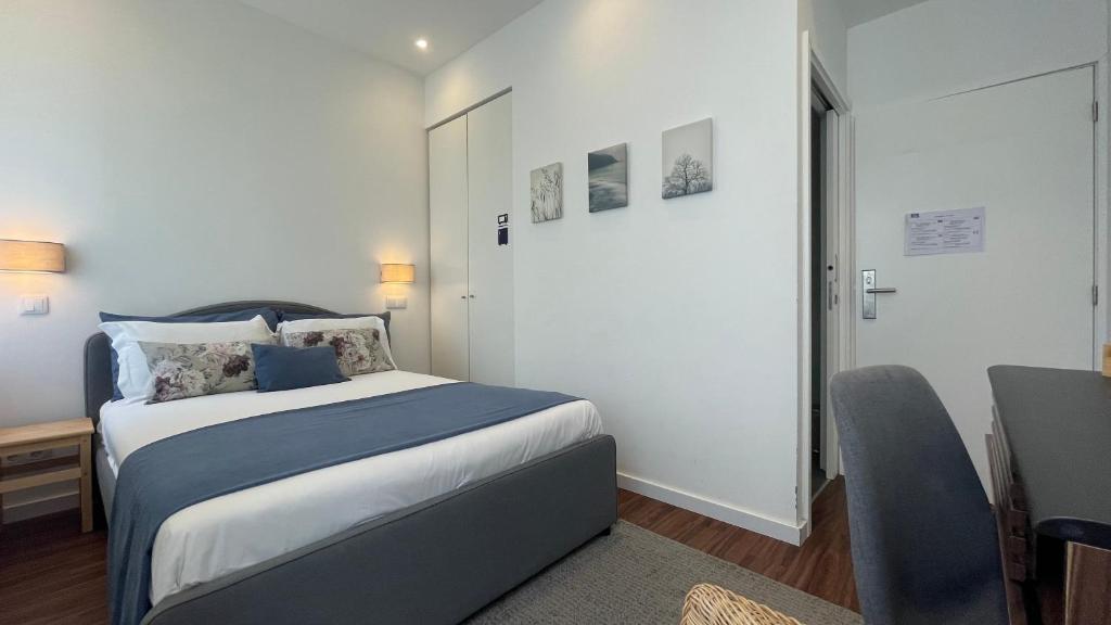 a bedroom with a bed and a desk and a chair at MyTrip Porto in Matosinhos