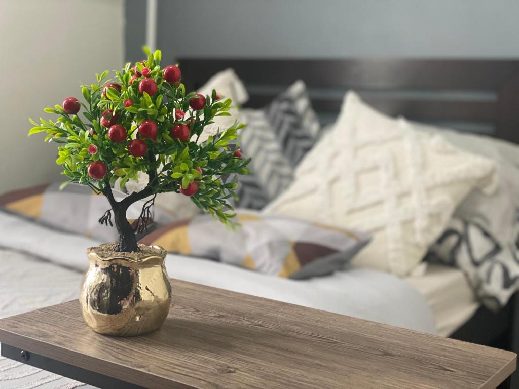 a vase with a plant on a table in front of a bed at Your Crib - kasara -19 D tower 1 in Manila