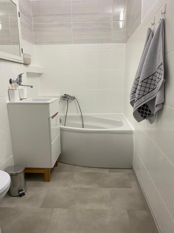 a bathroom with a tub and a sink and a toilet at Apartament Długie Ogrody 54 in Gdańsk