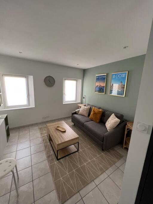 un salon avec un canapé et une table basse dans l'établissement Appartement climatisé en bord de mer, à La Ciotat