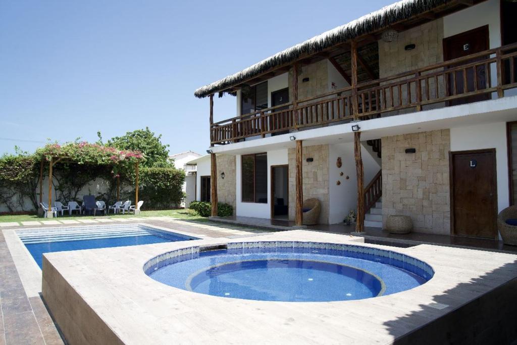 uma villa com piscina em frente a uma casa em CASA PUNTA CARNERO em Presidente Tamayo