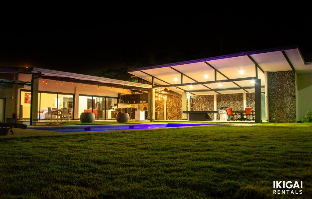 een groot huis 's nachts met een tuin bij Jm House in Alajuela