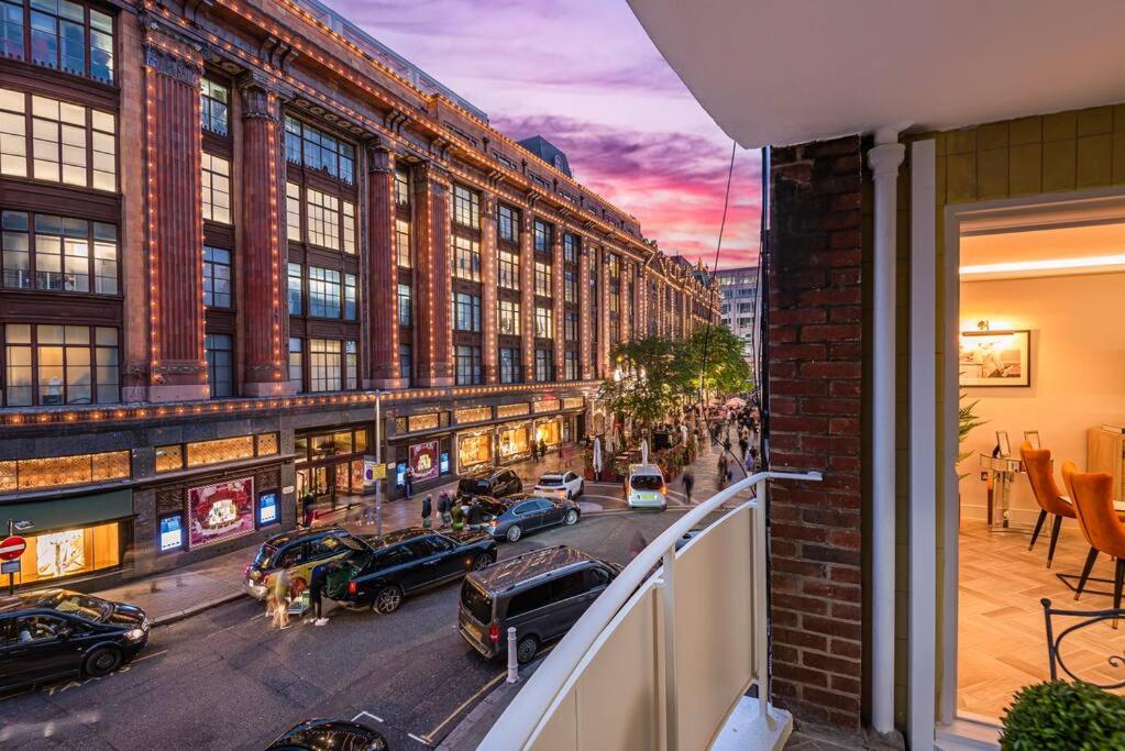 een balkon met uitzicht op een straat met auto's bij 39 steps to Harrods 2 Beds with AC in Londen