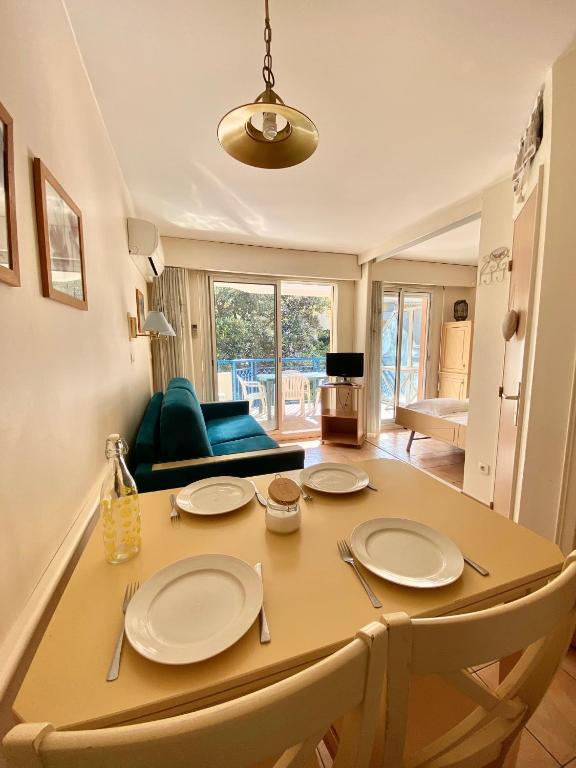 - une table à manger avec 2 chaises et une table dans l'établissement Joli 2 pièces vue jardin 50m plage Parking Clim, à Menton