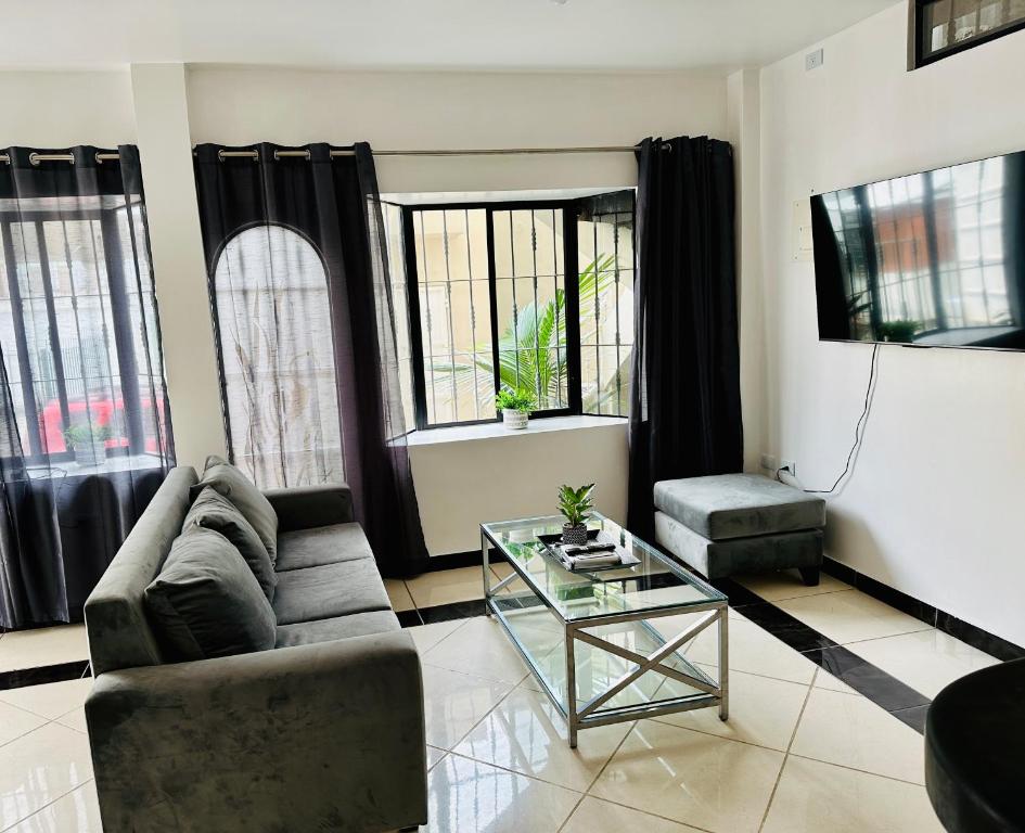 uma sala de estar com um sofá e uma mesa de vidro em Comfortable 3-Bedroom Condo in Bellavista, Guayaquil em Guayaquil
