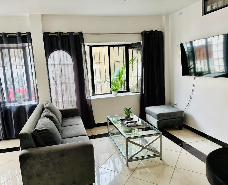 a living room with a couch and a glass table at Comfortable 3-Bedroom Apartment, close to the American Consulate in Guayaquil