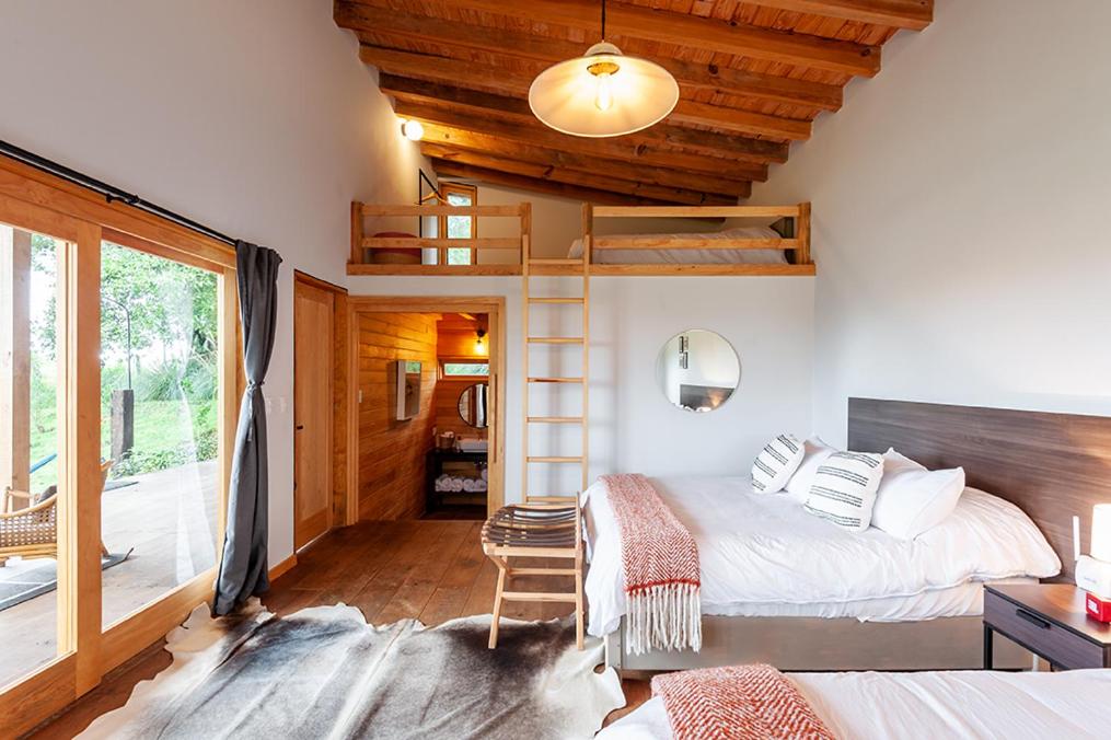 1 dormitorio con 2 camas y balcón en El Aile San Simón en Valle de Bravo
