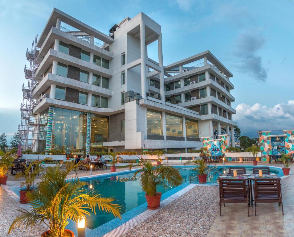 a large building with a pool in front of it at The Solitaire in Dehradun
