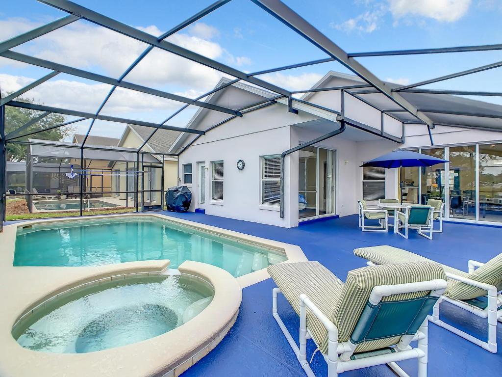 a pool with chairs and a hot tub at Family retreat w pool near Disney & parks in Orlando