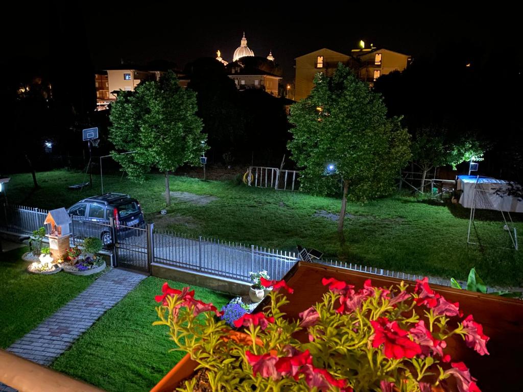 Blick auf einen Park in der Nacht mit roten Blumen in der Unterkunft Appartamento Antonietta-Assisi in Santa Maria degli Angeli