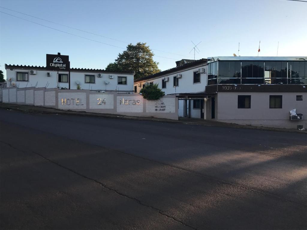 eine leere Straße mit zwei Gebäuden und einem Zaun in der Unterkunft HOTEL CITYY in Ijuí