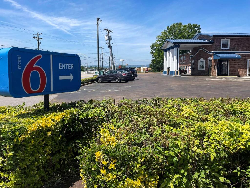 una gasolinera con un cartel en un estacionamiento en Motel 6-East Ridge, TN en Chattanooga