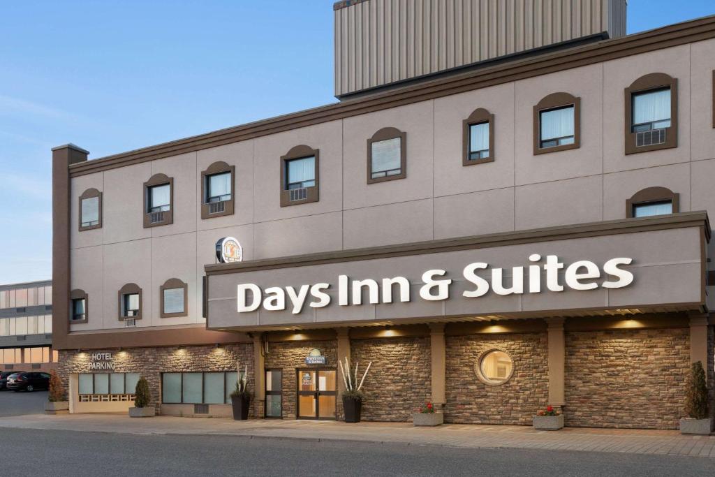 un edificio con un cartel que lee días posada y suites en Days Inn & Suites by Wyndham Sault Ste. Marie ON, en Sault Ste. Marie