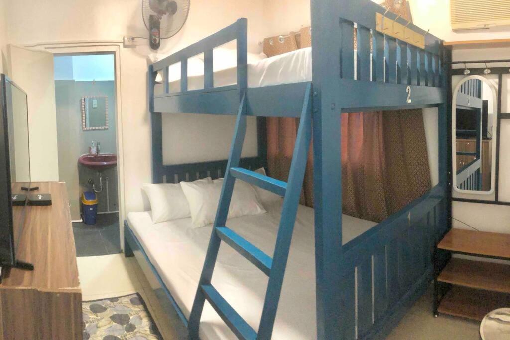 Litera azul con sofá blanco en una habitación en ANGZIA Private Pool & Resort Calamba, en Calambá