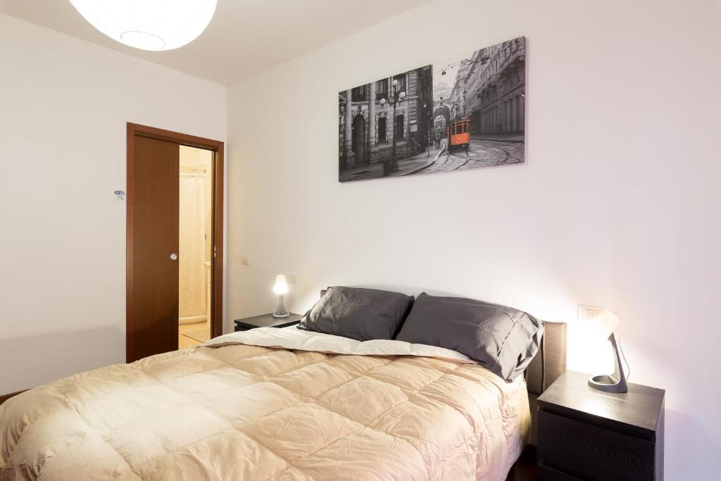 um quarto com uma cama e uma fotografia na parede em [Strategico Rho Fiera-Milano] Vanzago Home Deluxe em Vanzago