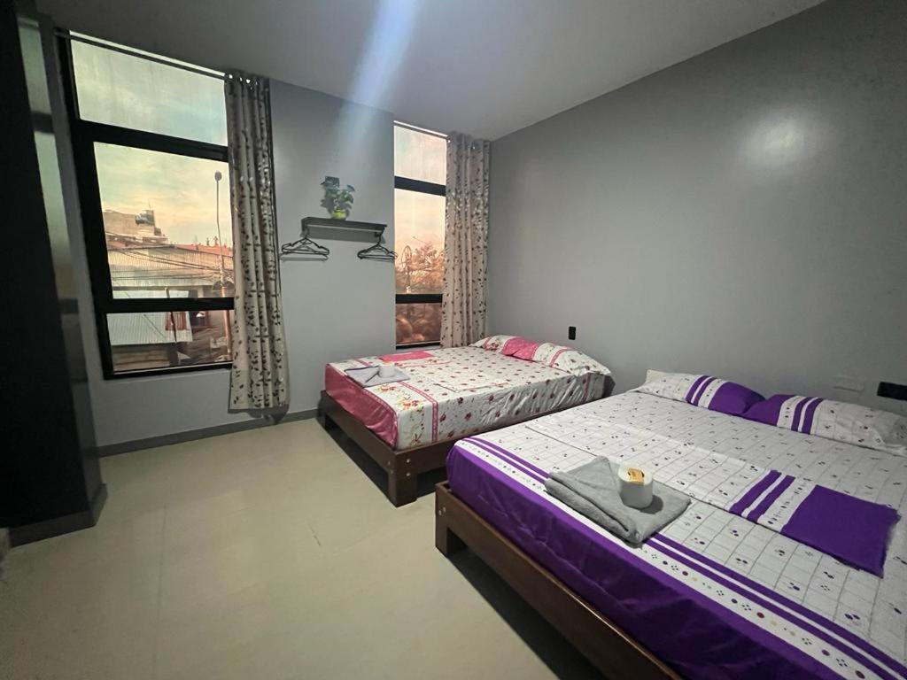 a bedroom with two beds and a window at Adrian´s Hotel in Pucallpa