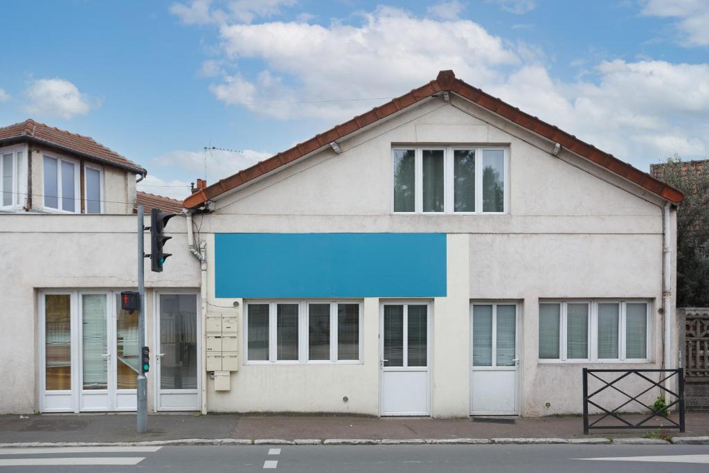 a white building with a blue banner on the front at Blanc Mesnil centre ville F3 in Le Blanc-Mesnil