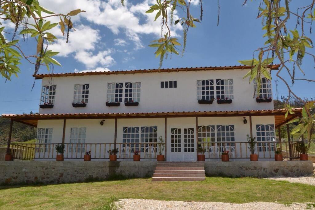 a large white house with white windows at VILLA ERIKA comoda casa bellisima vista in Paipa