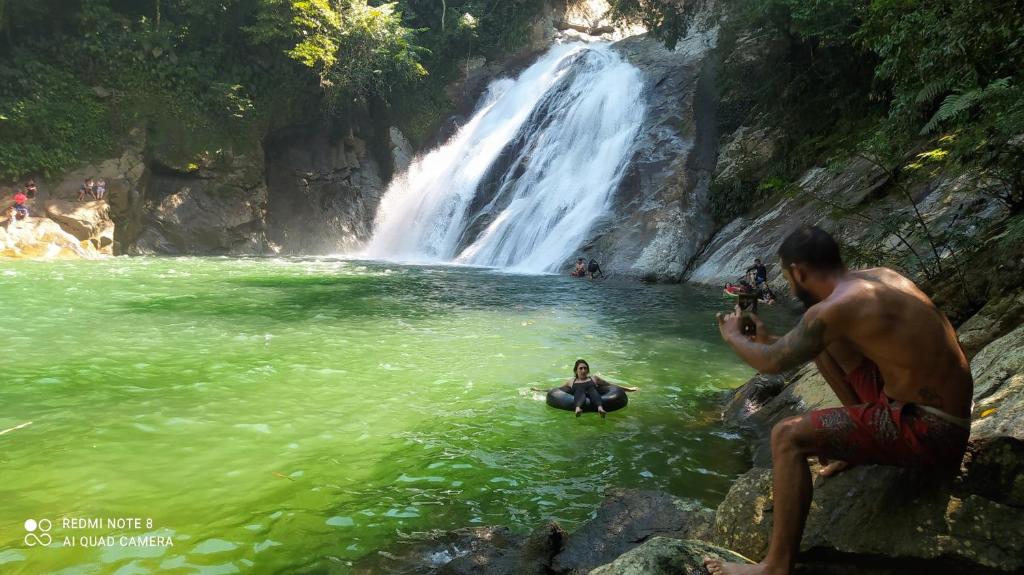 un hombre tomando una foto de una cascada en Hotel Campestre La Casona, en San Luis