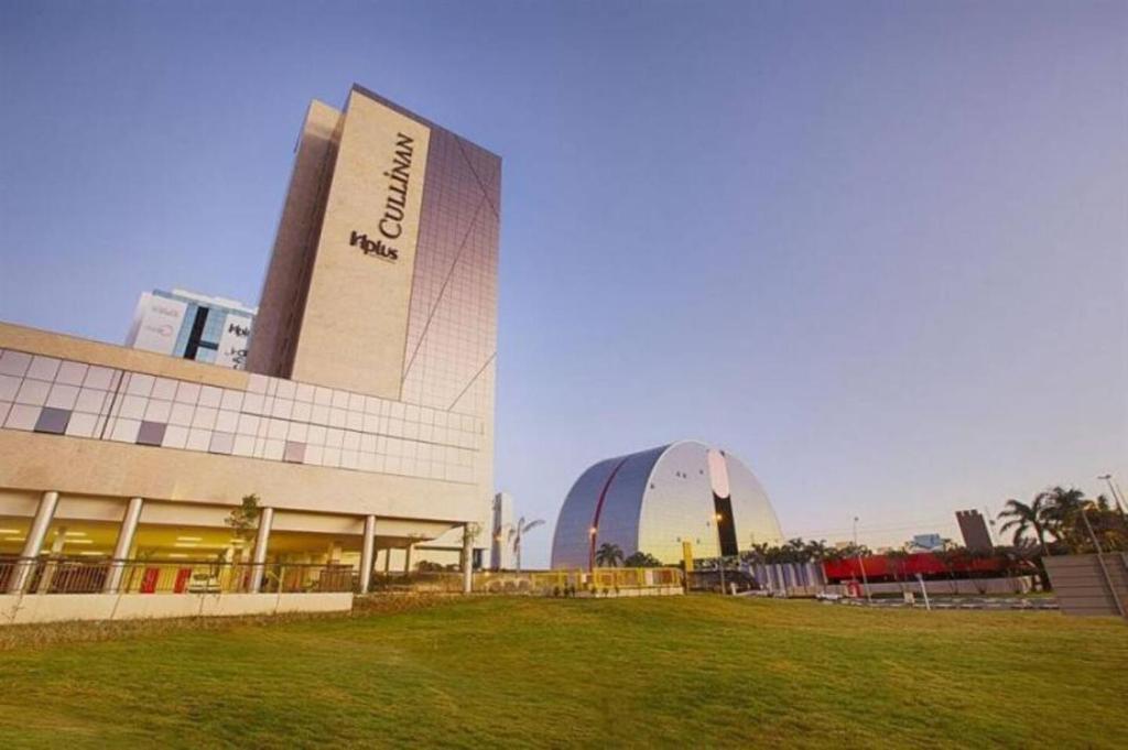a large building with a grass field in front of it at CULLINAN HOTEL FLAT DE LUXO apartamento 1409 in Brasilia