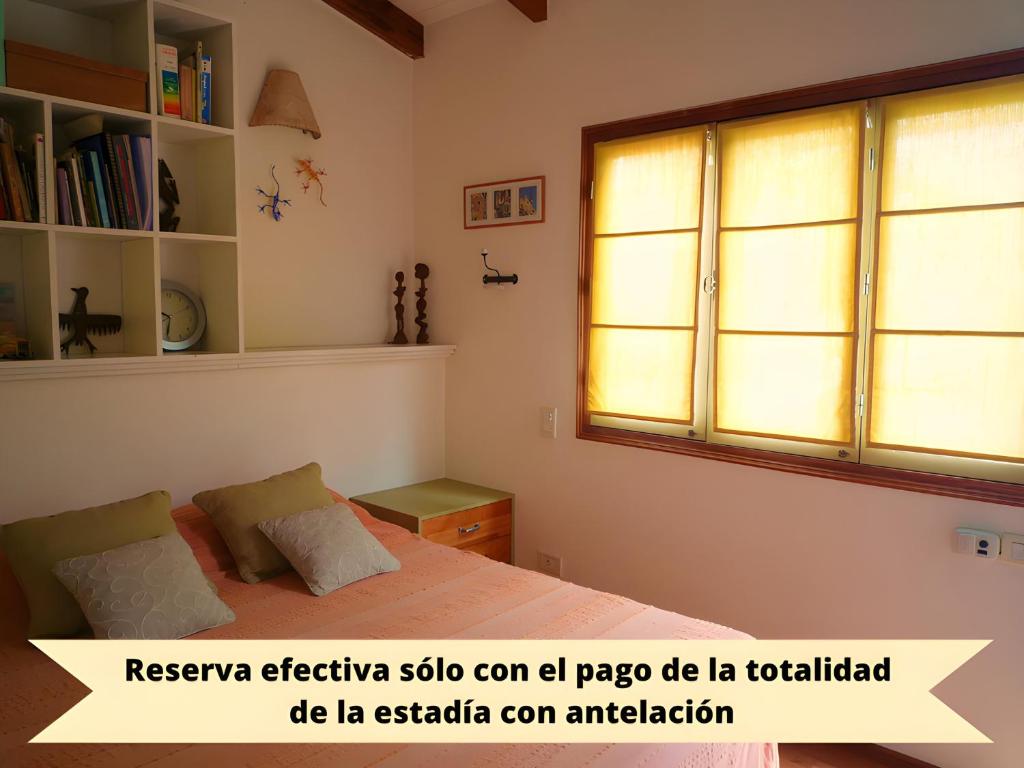 1 dormitorio con cama y ventana en CasaJardín en Rosario