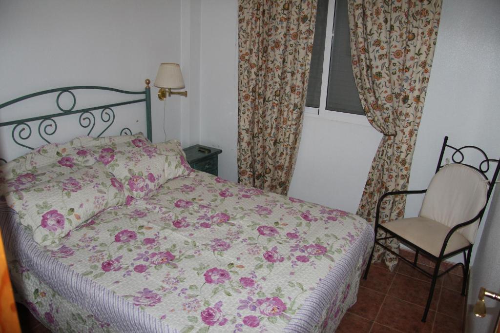 トレビエハにあるHoliday home Torre de Pisaのベッドルーム(ベッド1台、椅子、カーテン付)