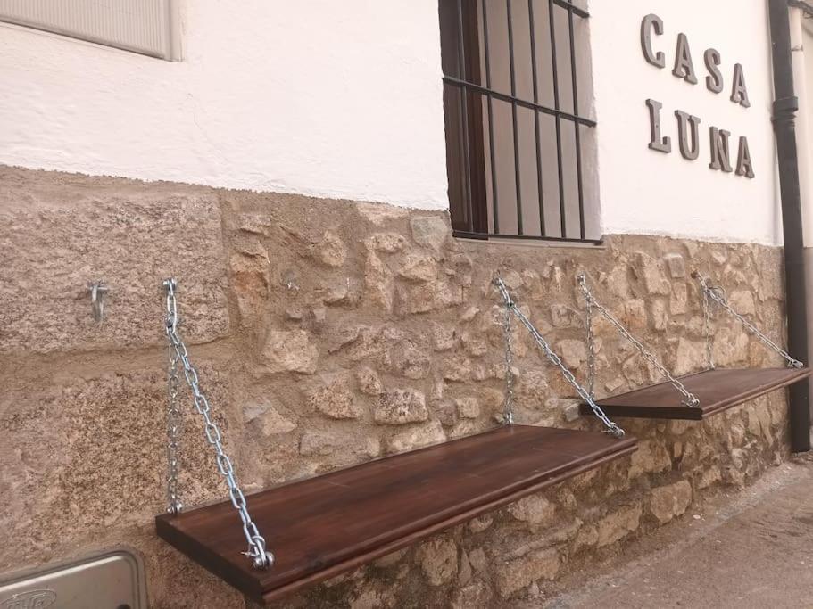 eine Holzbank an eine Steinmauer gekettet in der Unterkunft Casa Luna in Losar de la Vera